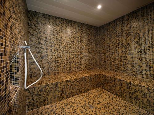 a bathroom with a shower with a tiled wall at Mercure Belfort Centre in Belfort