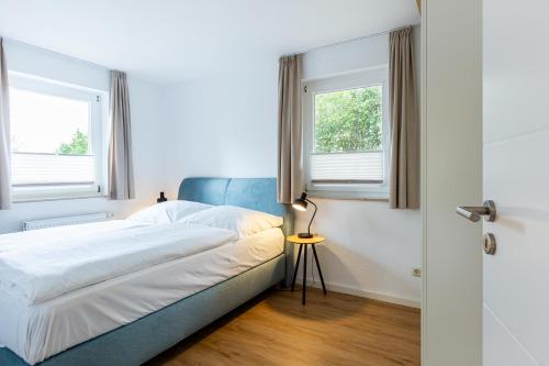 a bedroom with a bed and two windows at Boddenräuber 3 in Ahrenshoop