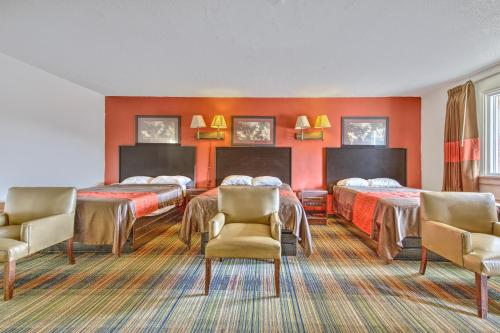 a hotel room with two beds and two chairs at OYO Palm Leaf Motel in Ashland