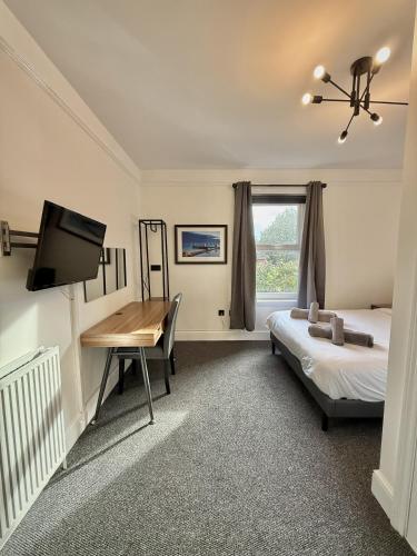 a bedroom with a desk and a bed and a desk sidx sidx sidx at Coastal Lodge in Leiston