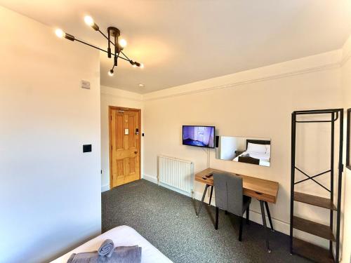 a room with a desk and a bed at Coastal Lodge in Leiston