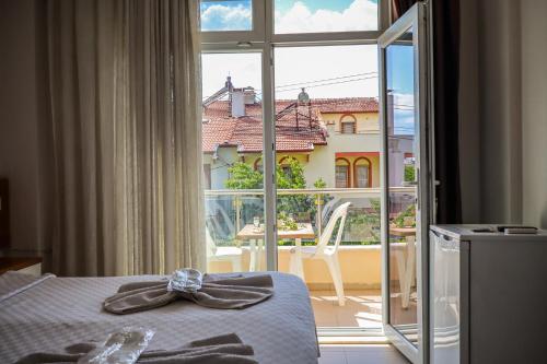 a bedroom with a bed and a window with a view at Özden Pansiyon in Burhaniye