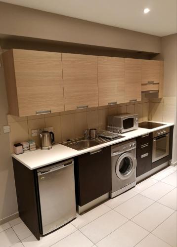a kitchen with a sink and a washing machine at Beachfront Amazing New Apartment in Limassol