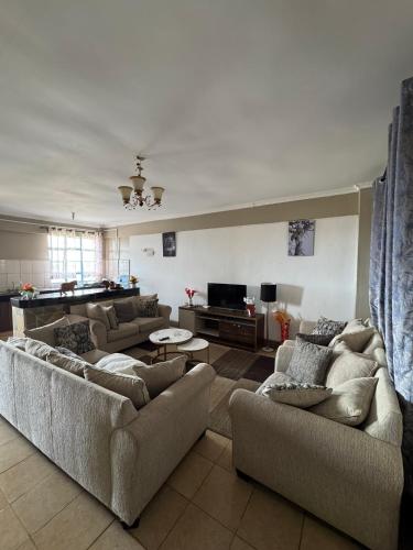 a living room with two couches and a television at Lovely 2-bedroom Fully-Furnished apartment in Nanyuki