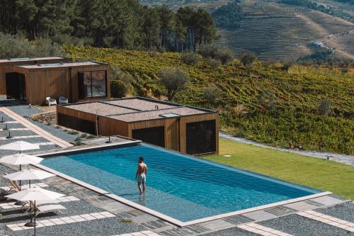 a man standing in a swimming pool next to a house at Five Sabrosa Senses in Sabrosa