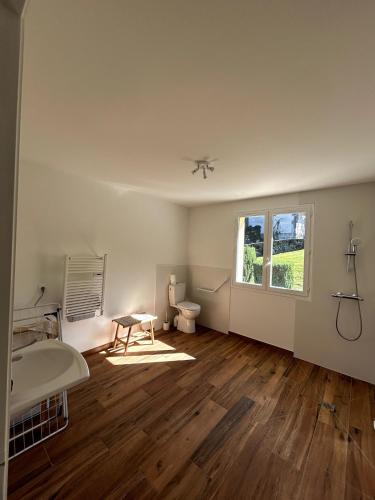 une chambre vide avec des toilettes et une fenêtre dans l'établissement Chez Mimi - Bellevue, à Raulhac