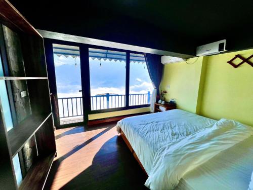 a bedroom with a bed and a large window at Hầu Thào Villa & Coffee in Sapa