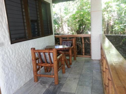 a porch with chairs and a table on a house at Kim's Garden in Anda