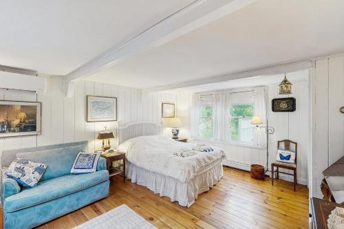 a bedroom with a bed and a blue couch at Soundmeadow House in Oak Bluffs