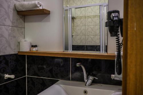 a bathroom with a phone on the wall above a sink at Özden Pansiyon in Burhaniye