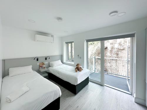 a bedroom with two beds and a teddy bear sitting between them at KCM Urban Retreats in Cobh