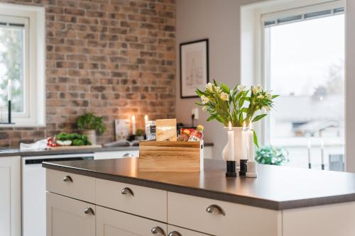 a kitchen with a counter with flowers in a vase at Guestly Homes - Spacious 2BR Executive Residence in Luleå