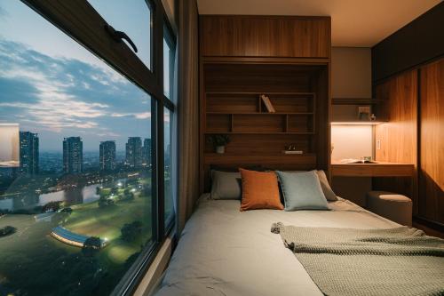 - une chambre avec une grande fenêtre donnant sur la ville dans l'établissement Sunset view Sky Villa in Ecopark resort with private pool, à Cong Luận