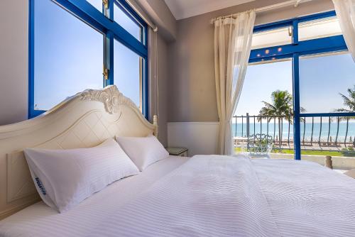 Un dormitorio con una cama grande con vista al mar. en White Sand Homestay, en Hualien City