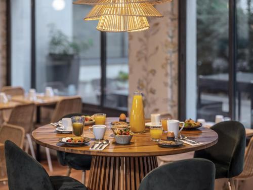 a table in a restaurant with food and drinks on it at Mercure Paris Gare Montparnasse TGV in Paris