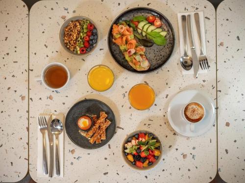 a table with plates of food and bowls of food at Mercure Paris Gare Montparnasse TGV in Paris