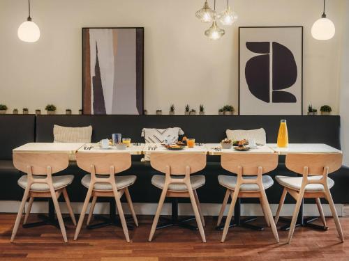 a dining room with a table and four chairs at Mercure Paris Gare Montparnasse TGV in Paris