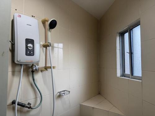 La salle de bains est pourvue d'une douche et d'un téléphone mural. dans l'établissement Dancenter Hotel Oriental, à Kota Kinabalu