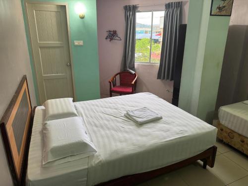 une chambre avec un lit avec des draps blancs et une fenêtre dans l'établissement Dancenter Hotel Oriental, à Kota Kinabalu