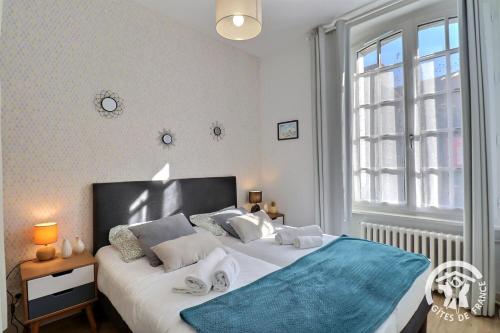 una camera da letto con un letto grande e una finestra di Le safran a Dinard