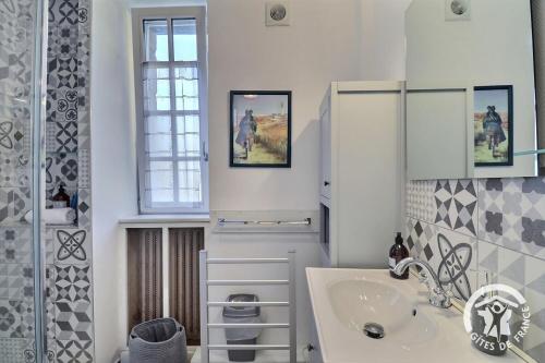 un bagno bianco con lavandino e specchio di Le safran a Dinard