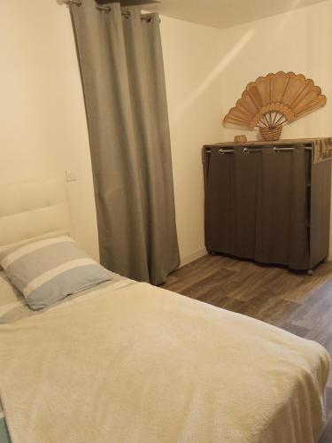 a bedroom with a bed with a curtain and a dresser at La Marina in Guipry-Messac