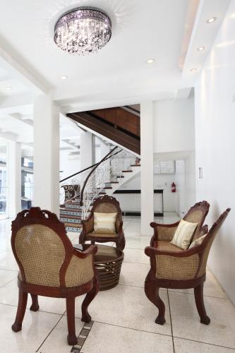 a lobby with three chairs and a staircase at Manila Lotus Hotel in Manila