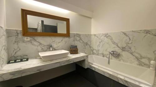 a bathroom with a sink and a tub and a mirror at Château De Jouques in Gémenos