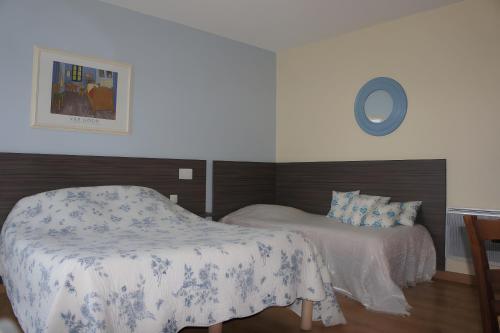 a bedroom with two beds and a table in it at Gîte La Combe Verte in Ratières