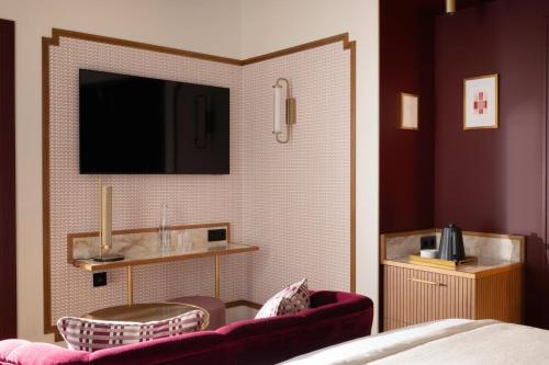 a hotel room with a tv on the wall at Hôtel Filigrane & Spa in Paris