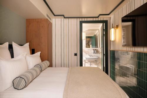 a bedroom with a bed and a bathroom with a sink at Hôtel Filigrane & Spa in Paris