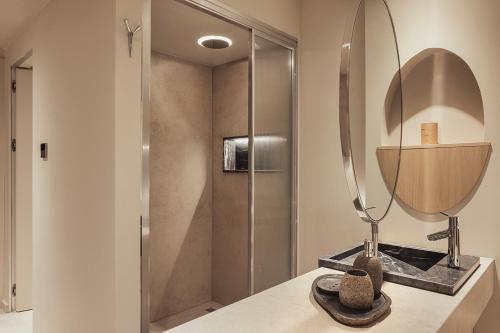 een badkamer met een douche en een spiegel op een aanrecht bij Dayone Kilyos Hotel in Kilyos