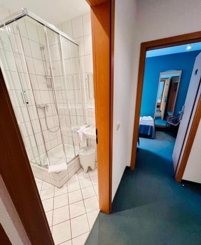a bathroom with a shower and a toilet and a sink at Hotel Gewürzmühle in Gera