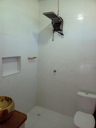 a white bathroom with a toilet and a sink at Luz Amazônia Lodge in Aiparuça