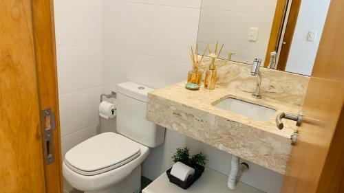 une salle de bain avec des toilettes blanches et un lavabo dans l'établissement APTO C/PISCINA AQUECIDA! Vc vai se surpreender!, à Gramado