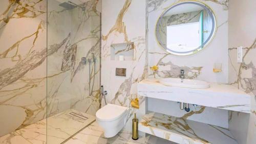 ein Badezimmer mit Waschbecken, Toilette und Spiegel in der Unterkunft Villa Gaspard - Piscine et jardin Privée Sans vis-à-vis Wifi HD in Oulad Akkou