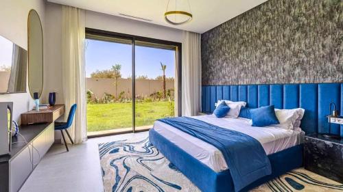 ein Schlafzimmer mit einem blauen Bett und einem großen Fenster in der Unterkunft Villa Gaspard - Piscine et jardin Privée Sans vis-à-vis Wifi HD in Oulad Akkou