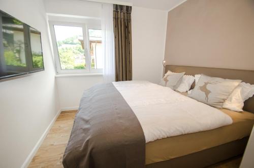 ein Bett in einem Zimmer mit Fenster in der Unterkunft Penthouse Waterside by All in One Apartments in Zell am See