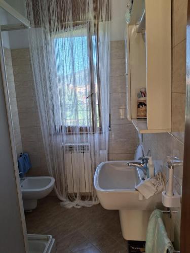 Un baño con lavabo, inodoro y ducha. en B&B Balcone sul Fiume, en Zogno