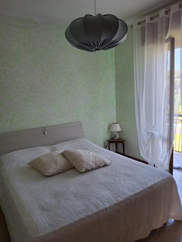 Un dormitorio con una cama blanca con dos almohadas encima. en B&B Balcone sul Fiume, en Zogno
