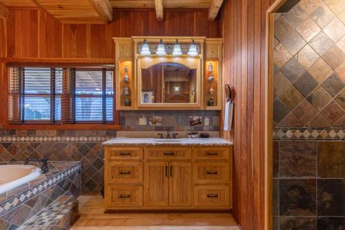 un baño con lavabo y espejo en Grand Vista Lodge, en West Jefferson