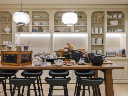 einen Esstisch mit Stühlen und Geschirr darauf in der Unterkunft Mercure Bordeaux Centre Gare Atlantic in Bordeaux