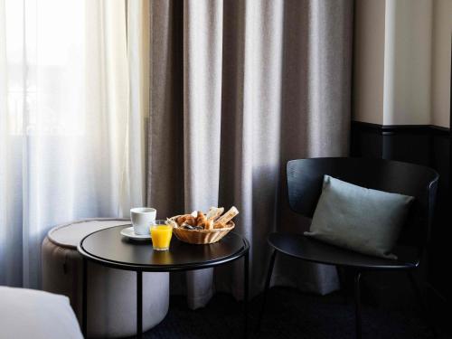 ein Tisch mit einer Schüssel Brot und einer Tasse Kaffee in der Unterkunft Mercure Bordeaux Centre Gare Atlantic in Bordeaux