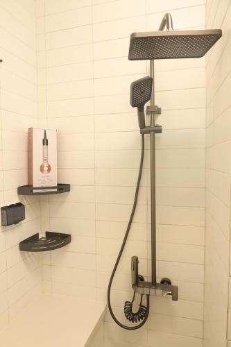 a shower in a bathroom with a blow dryer at Dfour Home Ngõ Gạch - Old Quarter in Hanoi