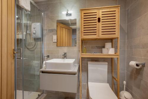 une salle de bain avec un lavabo, des toilettes et une douche dans l'établissement The Old Bank House - St Monans, à Saint Monance