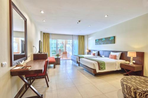 a hotel room with a bed and a desk at The Heritage Pattaya Beachfront Resort in Pattaya South