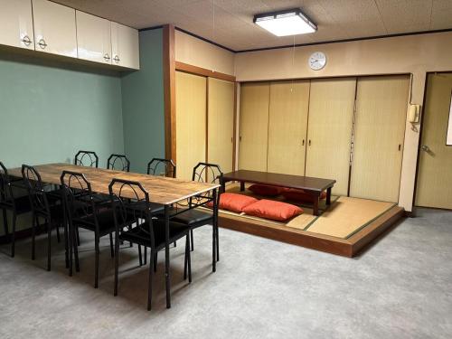 a conference room with a table and chairs and a bench at 桑名のお宿三栄町 桑名駅徒歩圏 ナガシマスパーランド なばなの里 近郊一軒家 in Kuwana