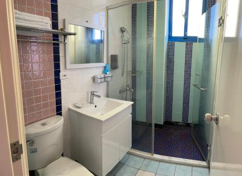 Un baño con ducha, inodoro y lavabo. en White Sand Homestay, en Hualien City