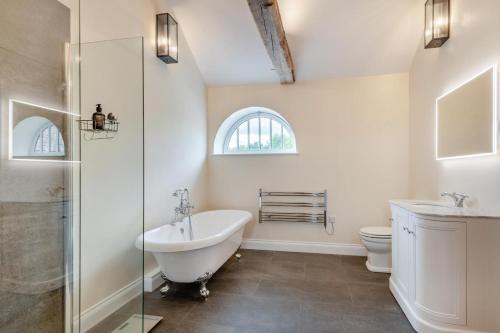 une salle de bain avec une baignoire, un lavabo et des toilettes dans l'établissement Iken Barn, à Neatishead