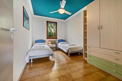 two twin beds in a room with a blue ceiling at Casa Tuly 1 in Brenzone sul Garda